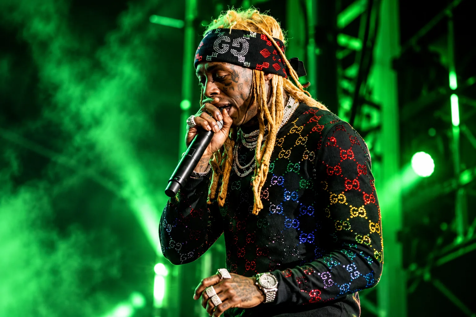 Music artist performing under green stage lights